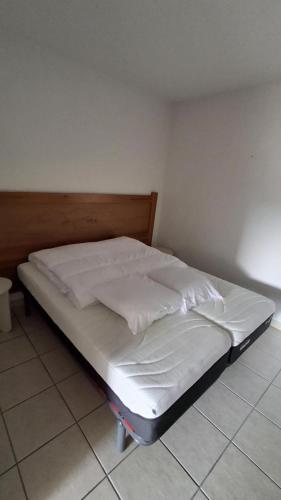 a bed in a room with white sheets and pillows at Les Abeilles in Trébas