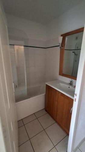 a bathroom with a tub and a sink and a mirror at Les Abeilles in Trébas