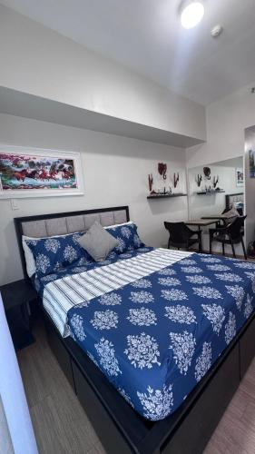 a bedroom with a bed with a blue comforter at Eve's Condo in Cagayan de Oro