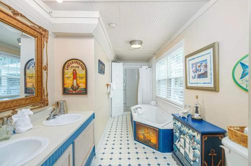 a bathroom with two sinks and a bath tub at Tybee Island Inn Bed & Breakfast in Tybee Island