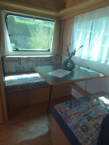 a small room with a table and a window at La caravane de l'enchanteresse in Philippeville