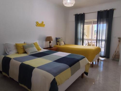 two beds in a room with yellow and blue at BEACH house in Sesimbra