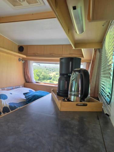 a room with a coffee maker on a table in an rv at La caravane de l'enchanteresse in Philippeville