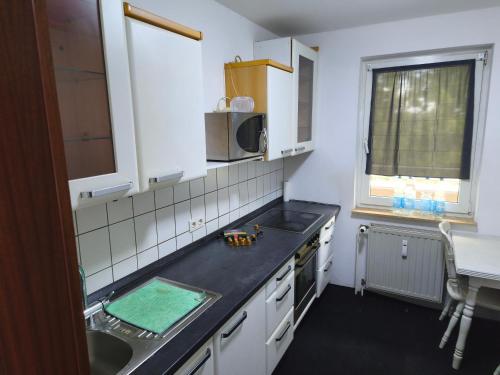 a small kitchen with a sink and a microwave at Bochum Wohnung in Bochum