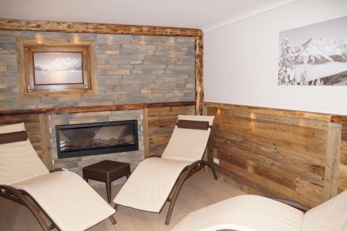 a room with chairs and a fireplace at Hotel am Sonnenhügel in Filzmoos