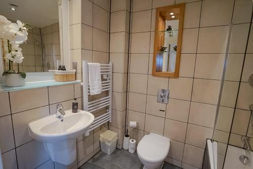 a bathroom with a sink and a toilet at Stylish 2-Bed Apartment, Free Parking, Walk to Hospital & Uni in Sheffield