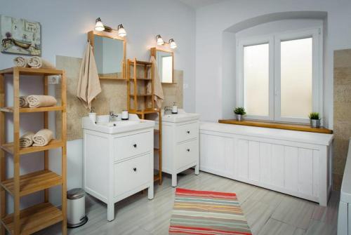 a bathroom with two sinks and a window at Luxury Beachfront Villa Kata in Rogotin