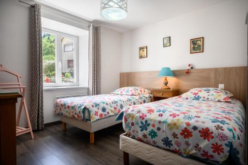 a bedroom with two beds and a window at Gite Les Jonquilles in Mittlach