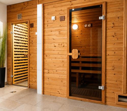a room with a wooden wall with a glass door at Villa Retró Harmónia in Visegrád
