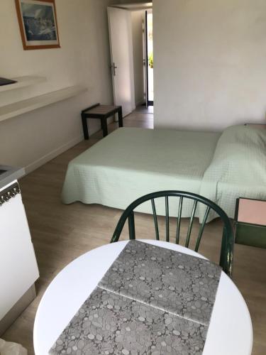 a room with two beds and a table and a table and chair at Studio piscine et vue mer in Trévou-Tréguignec
