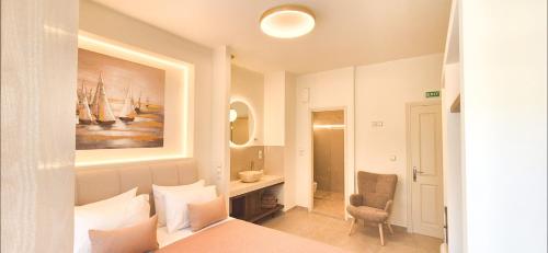 ein Schlafzimmer mit einem Bett, einem Stuhl und einem Gemälde in der Unterkunft Knossos Suite in Palekastro
