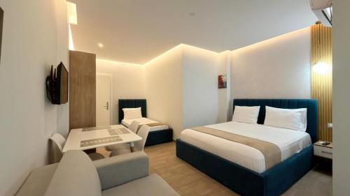 a small hotel room with a bed and a chair at HotelApart - DelMar in Durrës