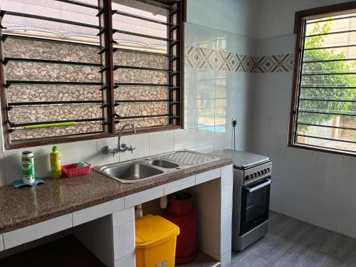 a kitchen with a sink and a stove at Lions Home in Diani Beach