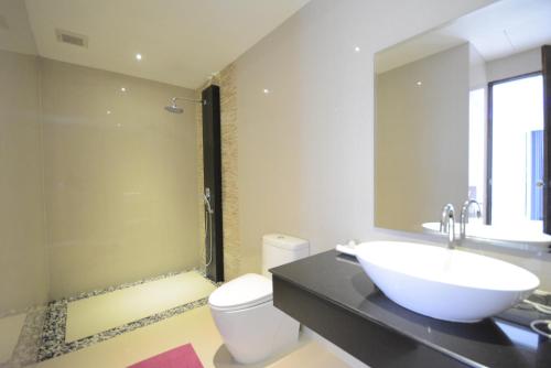 y baño con lavabo, aseo y espejo. en Rocking Chair Pool Villa, en Chaweng
