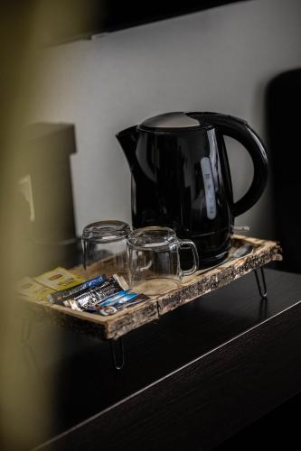a black tea kettle and glasses on a tray at Hotel Inn Salland in Raalte