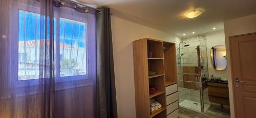 a bathroom with a shower and a window and a sink at Villa Jamgers in Martigues