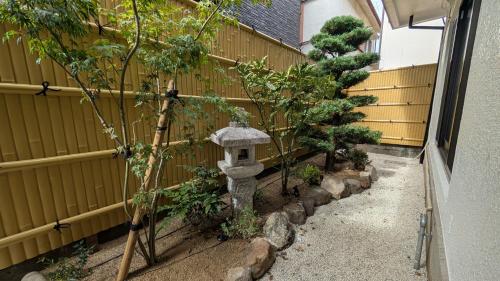 a garden with a bird house next to a fence at Dream Stays SORA in Izumi-Sano