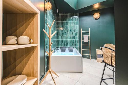 a bathroom with a tub and a green wall at SPA Balnéo des Sacres-REIMS-Centre Ville in Reims