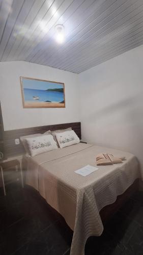 a bedroom with a bed with a picture on the wall at L&S casa da lagoa in Búzios