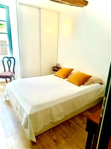 a bedroom with a large white bed with yellow pillows at Entre Pic et Rivière in Saint-Martin-de-Londres