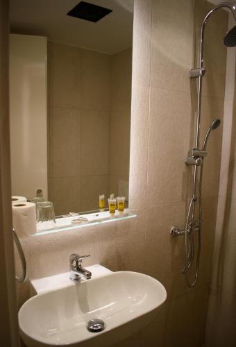 a bathroom with a sink and a mirror at Hotel ALS KARYSTOS in Karistos