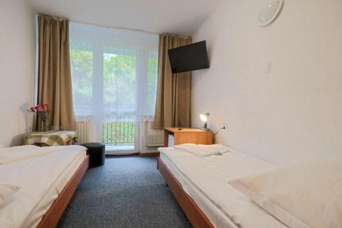 ein Hotelzimmer mit zwei Betten und einem Fenster in der Unterkunft Ośrodek Wypoczynkowy Eden Kąty Rybackie in Kąty Rybackie