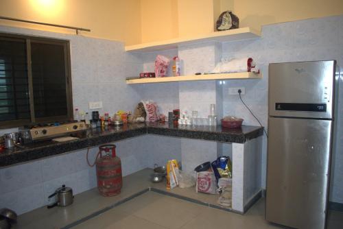 a kitchen with a stainless steel refrigerator and counters at Hotel Harsh Garden in Varanasi