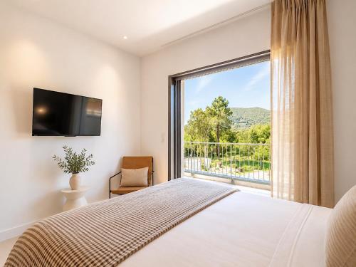 a bedroom with a bed and a large window at Villa Déoni in Zonza