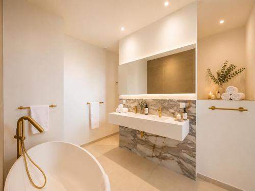 a white bathroom with a sink and a tub at Villa Déoni in Zonza