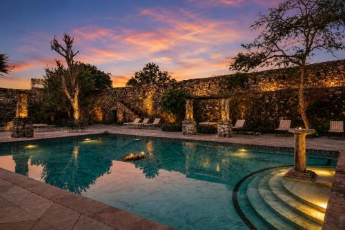 a swimming pool in front of a stone wall at Castle Bijaipur - A Luxury Heritage Resort, Chittorgarh in Bijaipur