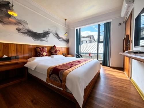 a bedroom with a large bed and a large window at 芮嘉民宿 阳朔西街店 in Yangshuo