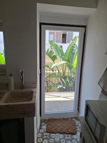 a bathroom with a door with a window and a sink at FONTE NOVA Setubal in Setúbal