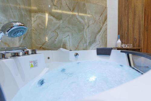 a white tub in a bathroom with a sink at Aqua Studios with Spa & Free Parking in Jagodina