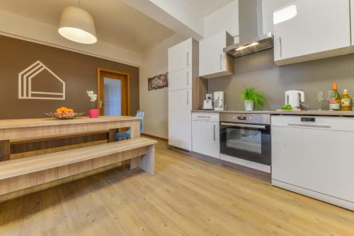 cocina con electrodomésticos blancos y suelo de madera en My Hostel en Múnich