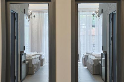 zwei Spiegel in einem Zimmer mit Sofas und einem Fenster in der Unterkunft Leader Hotel in Goris