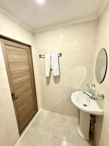 a white bathroom with a sink and a mirror at Harmony Inn in Almaty