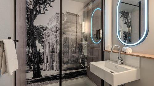 a bathroom with a sink and a shower at Campanile NATURE - Orange in Orange