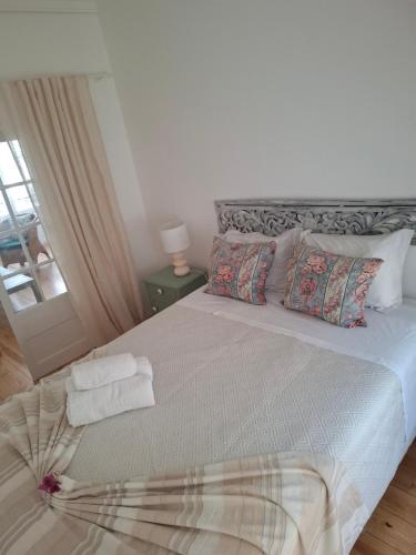 a bedroom with a large bed with towels on it at FONTE NOVA Setubal in Setúbal