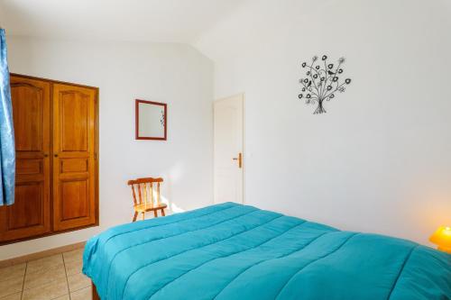 a bedroom with a blue bed and a wooden chair at Le Cade - La Fontinelle in Bessas