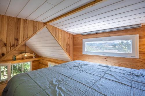 a bedroom with a bed and a window in a room at Tiny House au coeur de la nature in Bessuéjouls