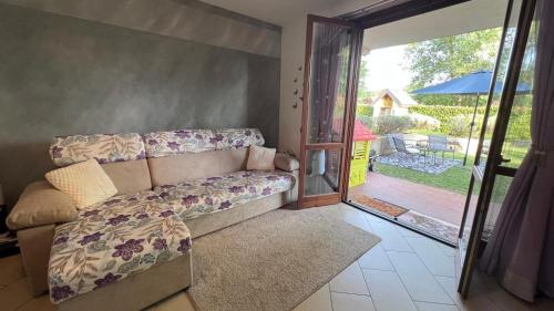 a living room with a couch and a sliding glass door at Lilac Cozy Retreat in Angera