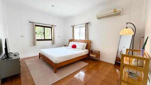 a bedroom with a bed and a television in it at Zen Trinity House in Ko Phangan