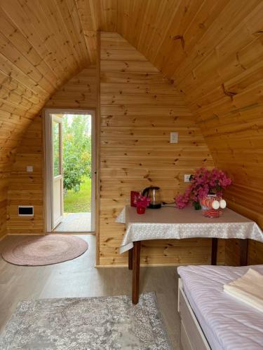 a room with a wooden wall with a table in it at Beshik Guest House in Bokonbayevo