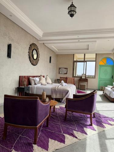 a bedroom with two beds and a purple rug at Dar Mimosa in Essaouira