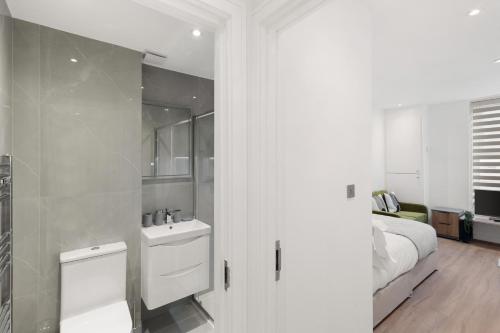 a white bathroom with a sink and a bed at Chic & Modern Beckenham Retreat in Beckenham