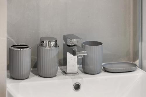 a bathroom with three trash cans and a sink at Chic & Modern Beckenham Retreat in Beckenham