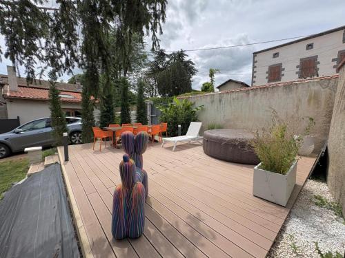 two women sitting on a wooden deck in a backyard at Gîte cottage & spa in Joze