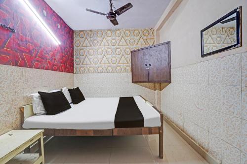a bedroom with a bed with a ceiling fan at Hotel O Shivam In in New Delhi