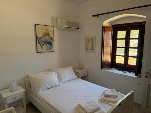 a bedroom with a bed with white sheets and a window at Villa Marco Polo in Agia Marina