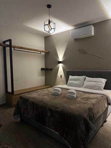 a bedroom with a large bed with two towels on it at AlexandRos Home in Áyioi Dhéka